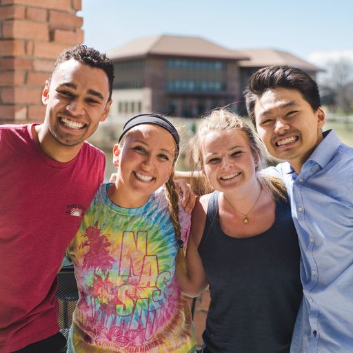 4 students standing in front of the camera, smiling